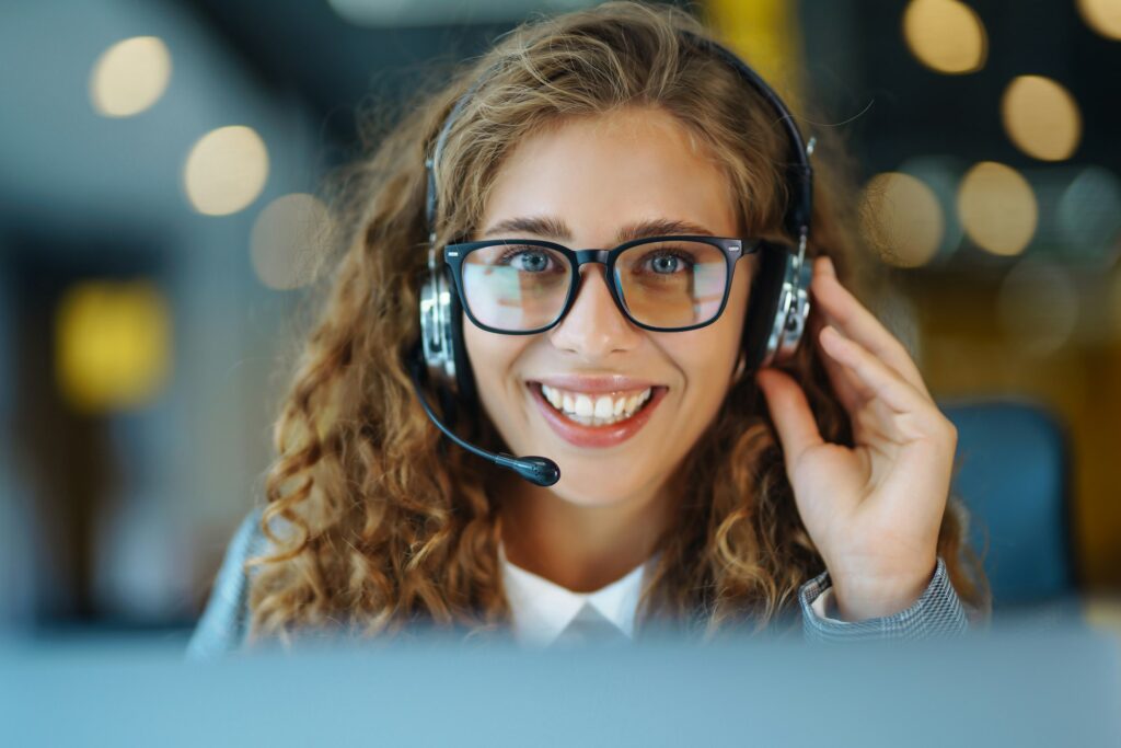 Call center agent with headset working on support hotline in modern office. Video conference.